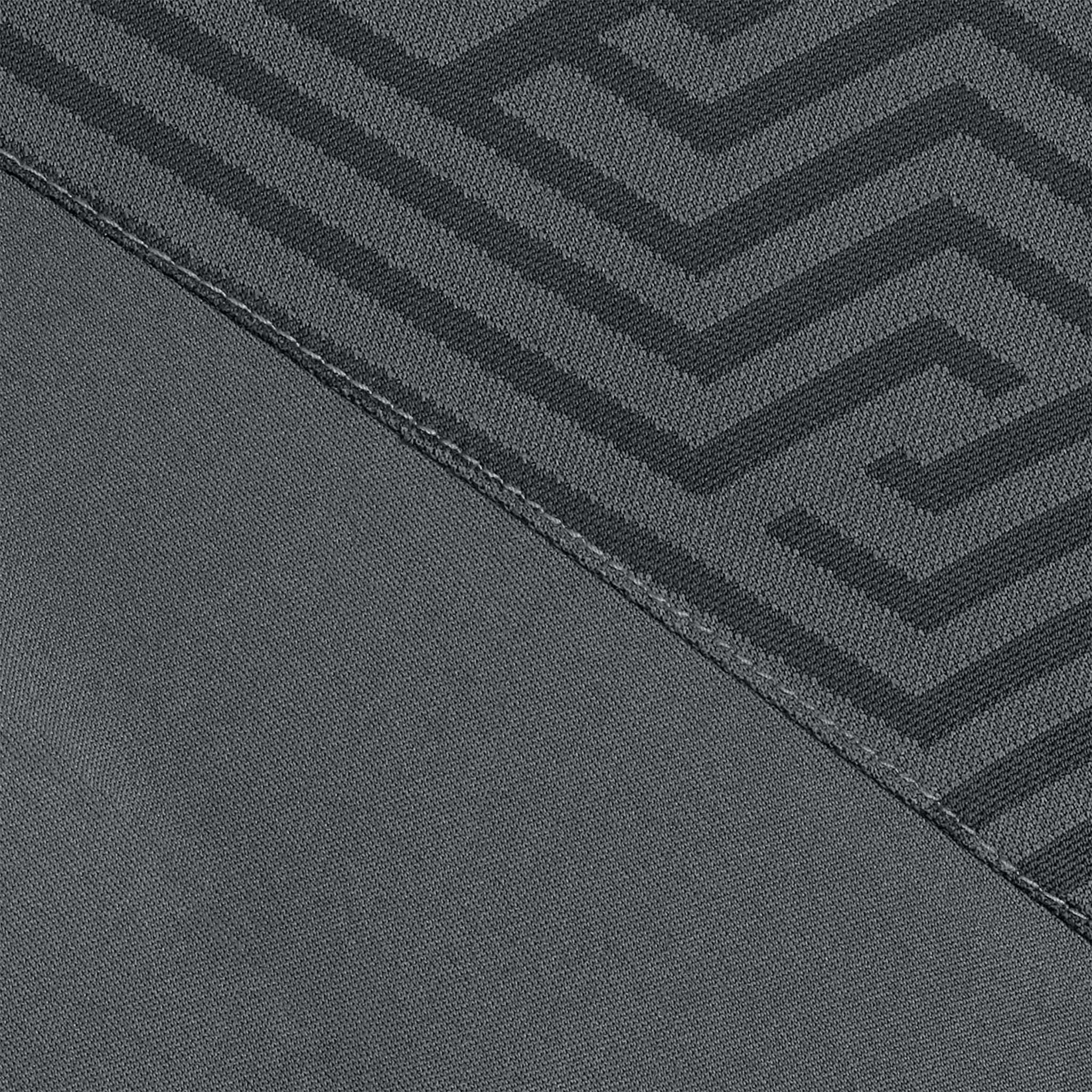 Närbild av Technical Polo Monaco v24 fritidskläder, grått tyg med svart geometriskt labyrintmönster