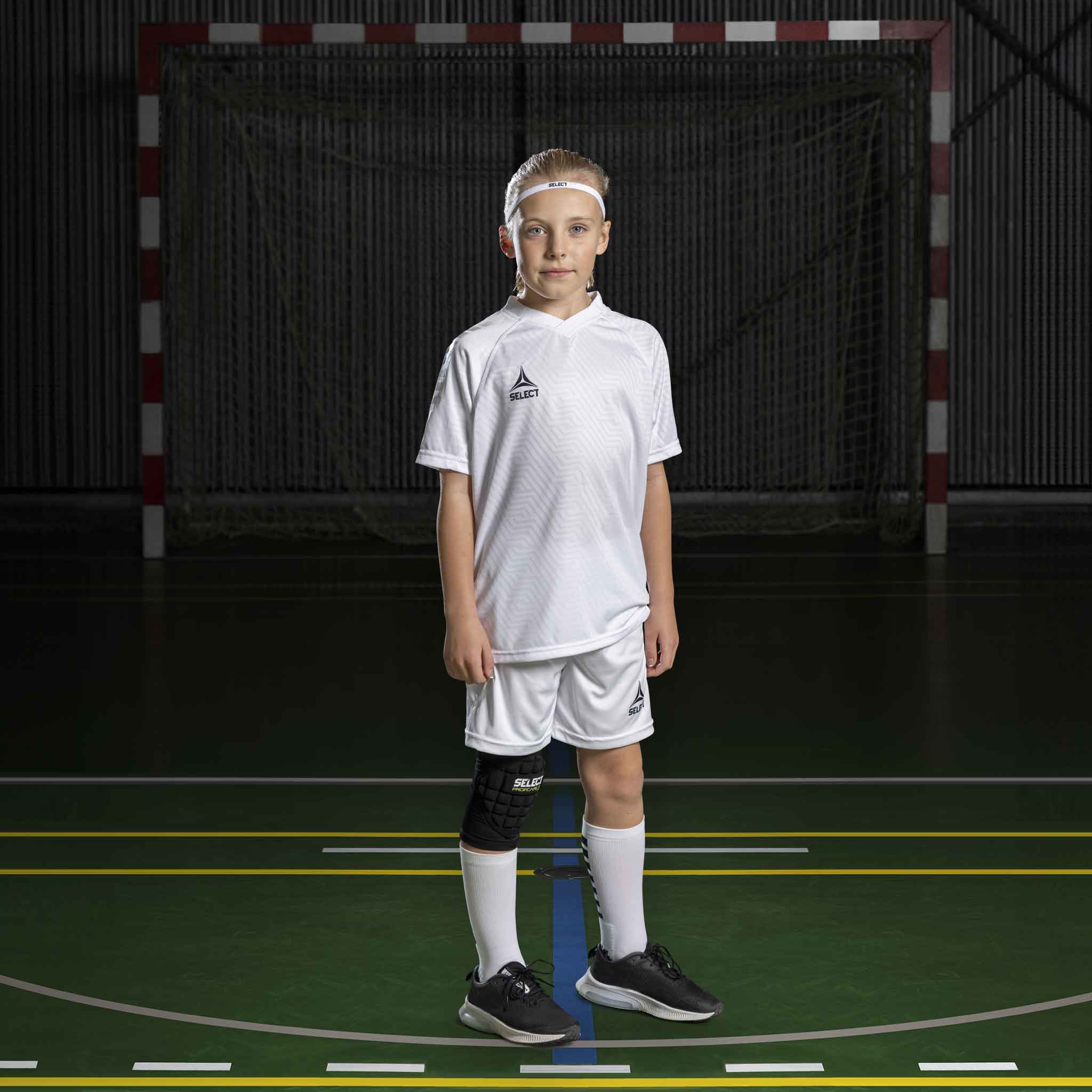 Handbollstjej i vita Player shorts Monaco v24 och matchande tröja, Match & Training wear, på inomhusplan.