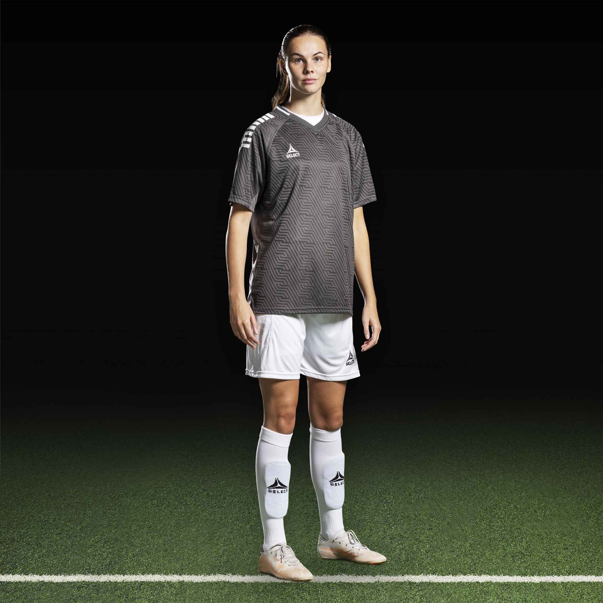 Kvinnlig fotbollsspelare i grå Player shirt S/S Monaco v24, vita shorts och strumpor. Match & Training wear.
