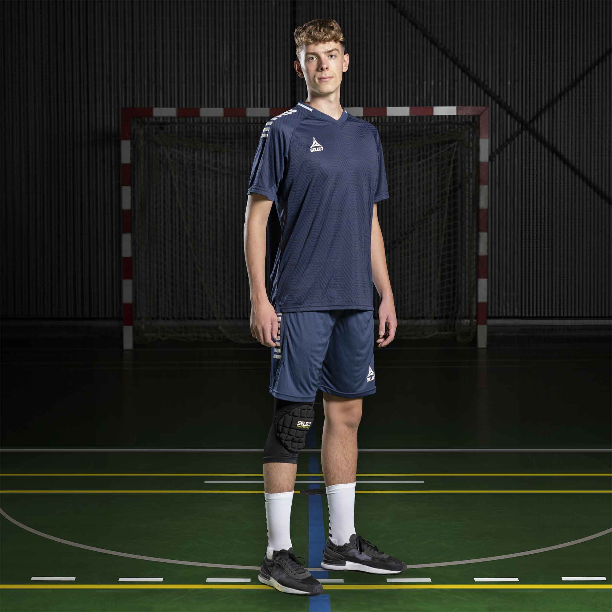 Manlig handbollsspelare i marinblå och vit Player shirt S/S Monaco v24, Match & Training wear, framifrån på planen.