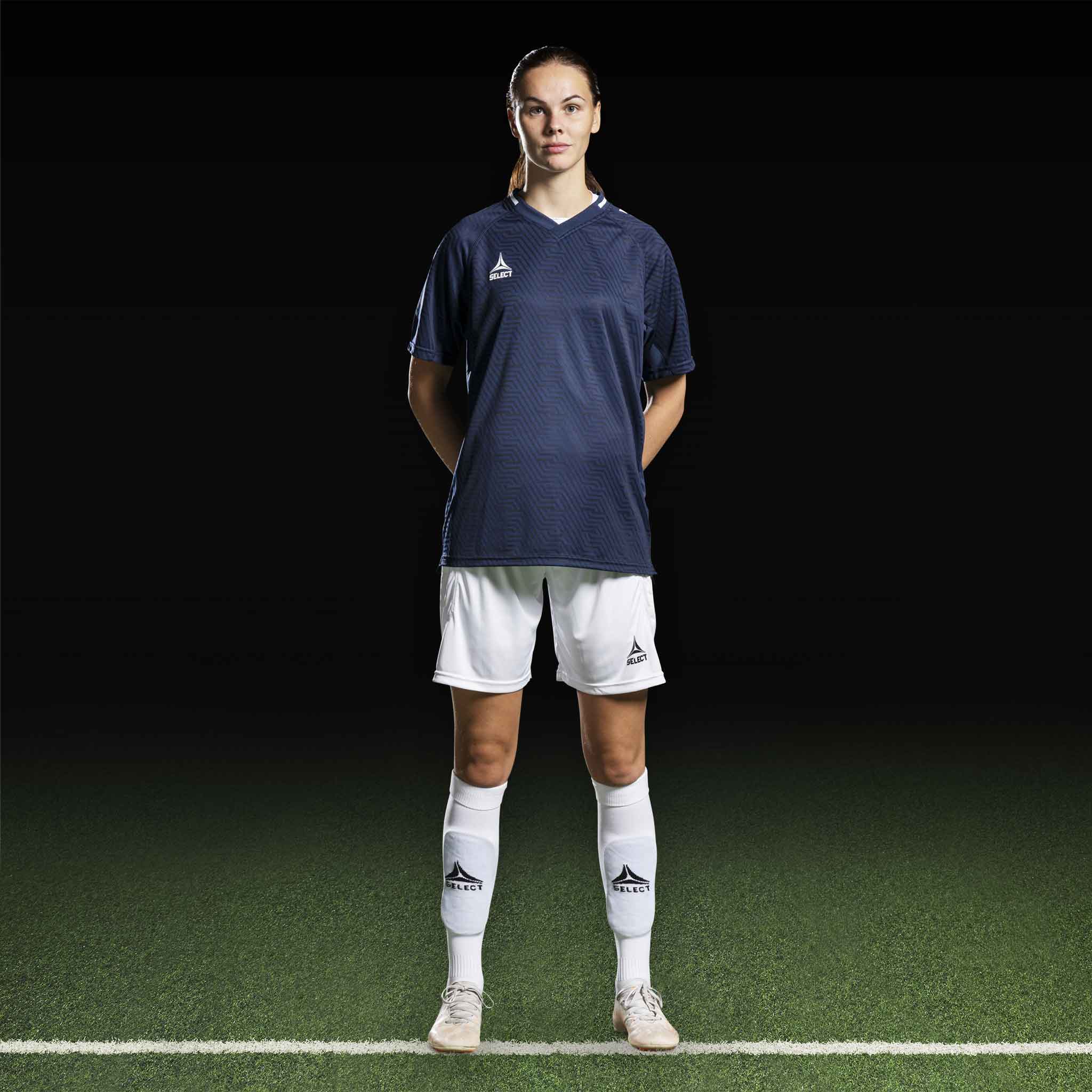 Kvinnlig fotbollsspelare i marinblå Player shirt S/S Monaco v24 och vita shorts, Match & Training wear.