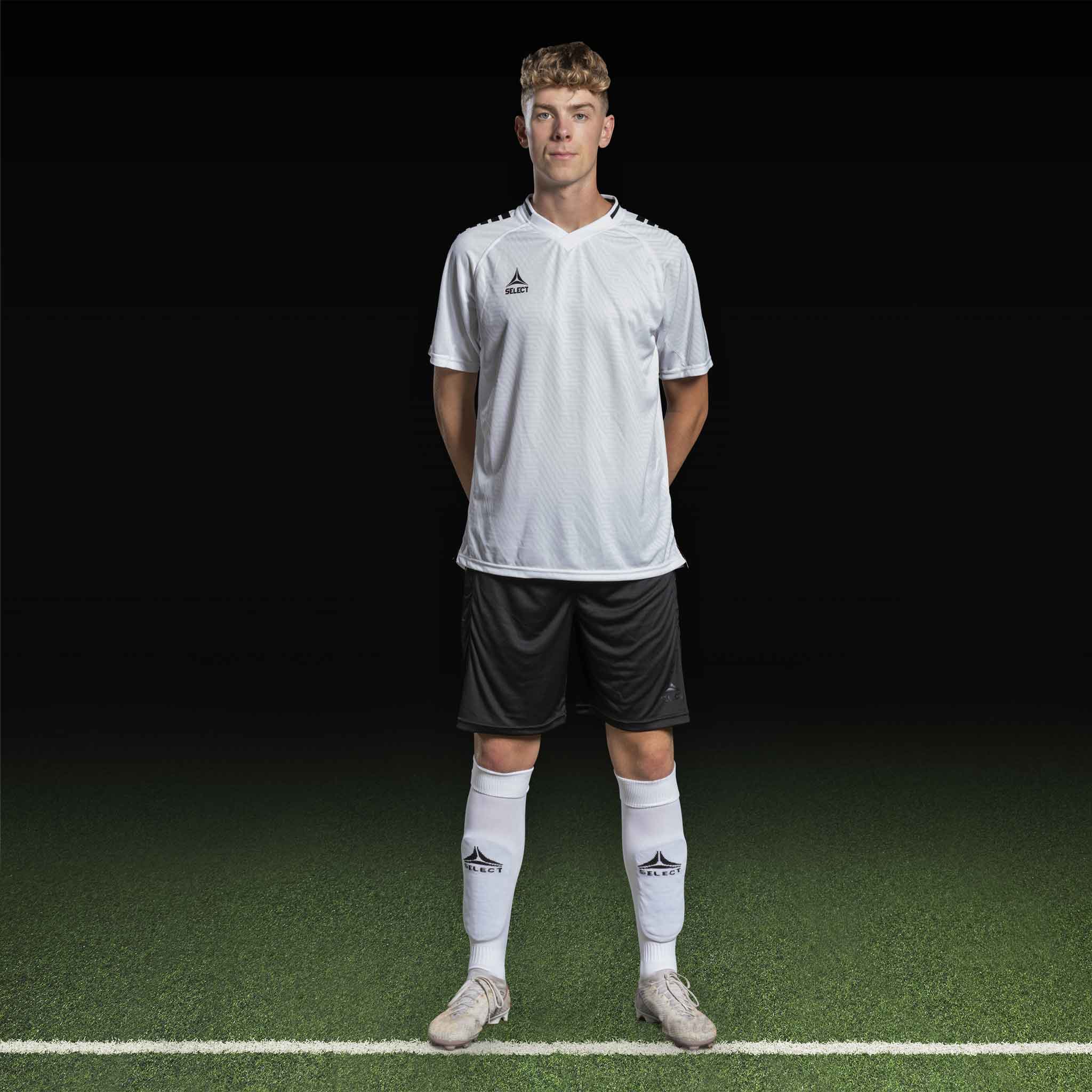 Manlig fotbollsspelare i vit Player shirt S/S Monaco v24 med svarta shorts, Match & Training wear, framifrån.