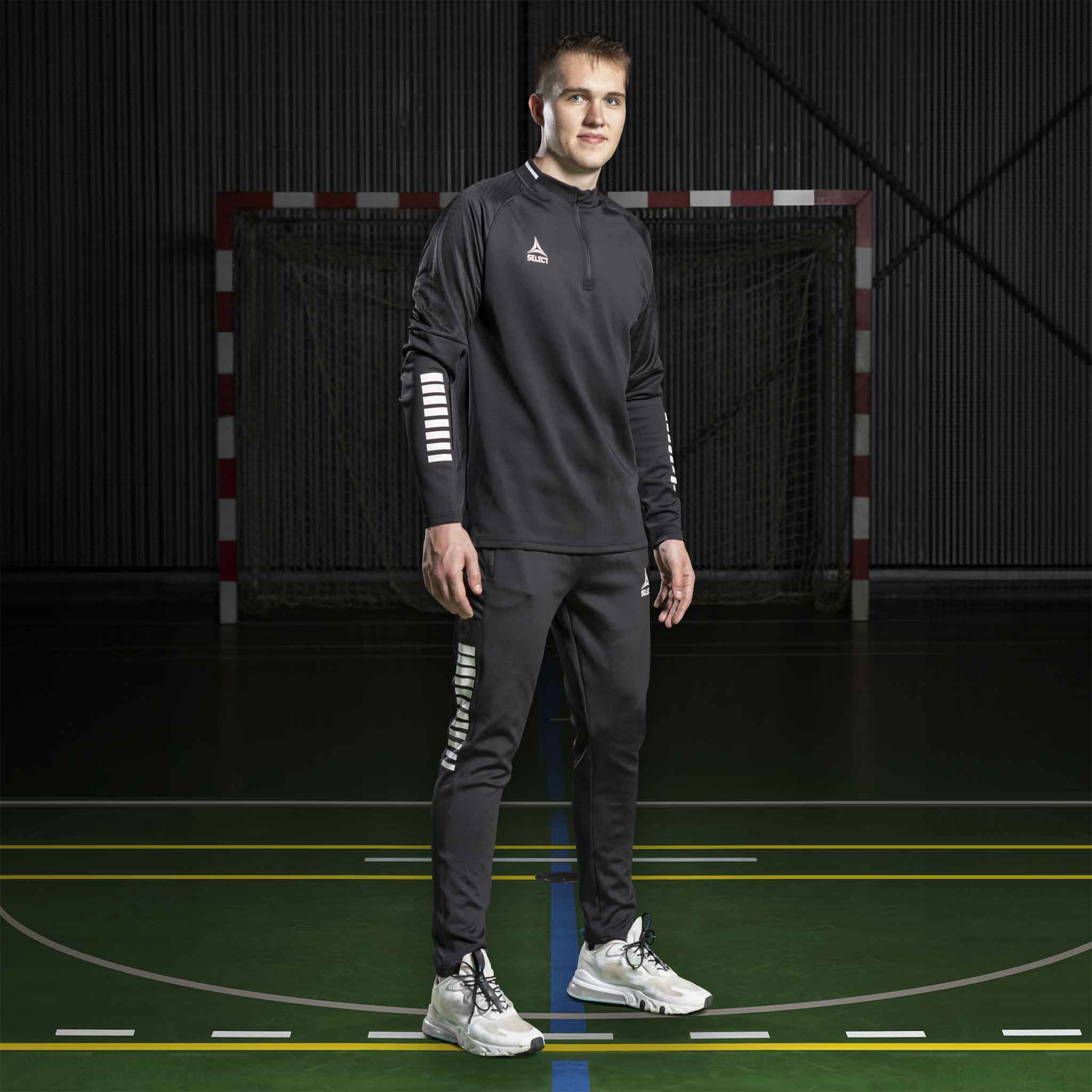 Manlig handbollsspelare i svart Training sweat 1/2 zip Monaco v24, Match & Training wear, på plan.