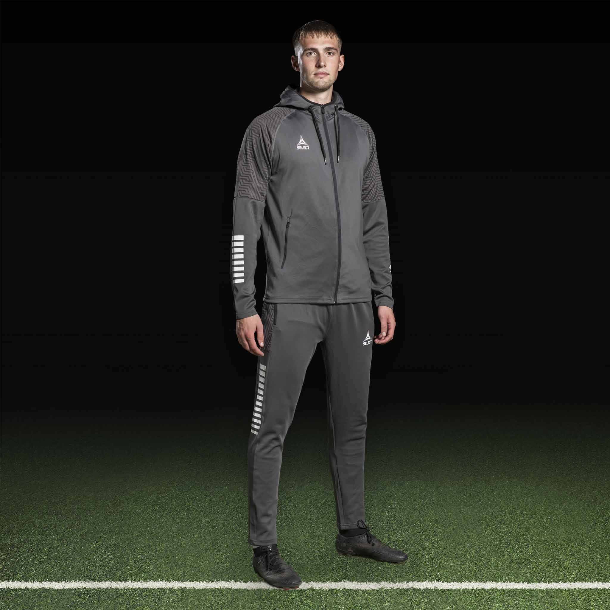 Manlig fotbollsspelare i grå och vit Zip hoodie Monaco v24, Match & Training wear, framifrån.
