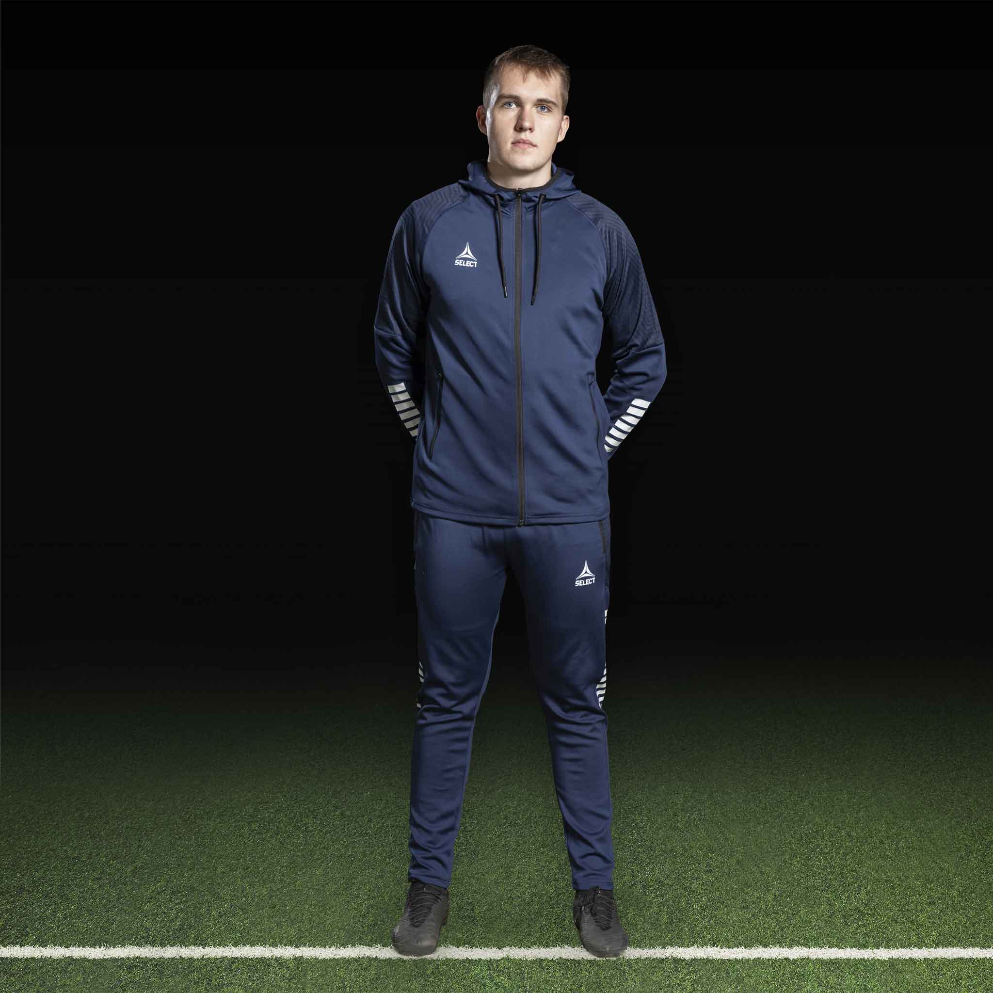 Manlig fotbollsspelare i marinblå och vit Zip hoodie Monaco v24, Match & Training wear, framifrån.