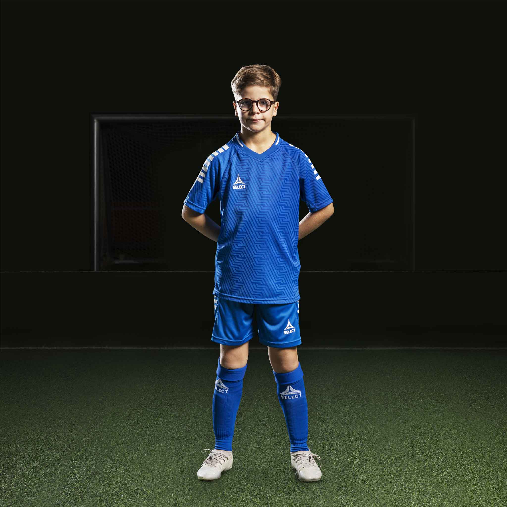Pojke fotbollsspelare i blå Player shorts Monaco v24 och matchande tröja, Match & Training wear, framifrån.