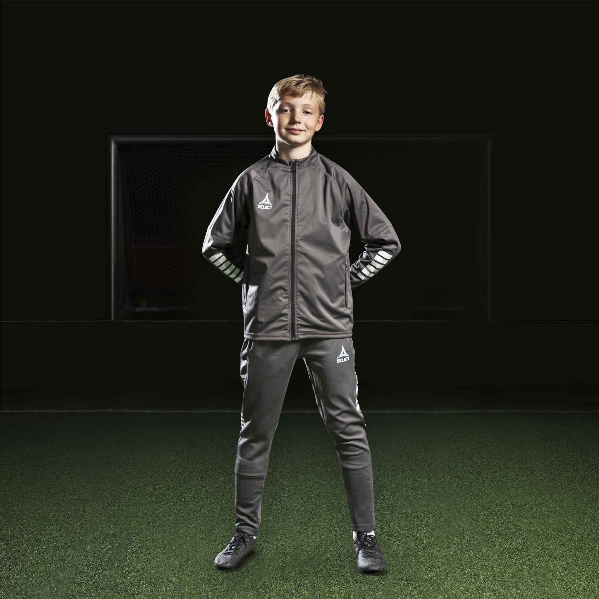 Pojke fotbollsspelare i grå och vit Training jacket Monaco v24, Match & Training wear.