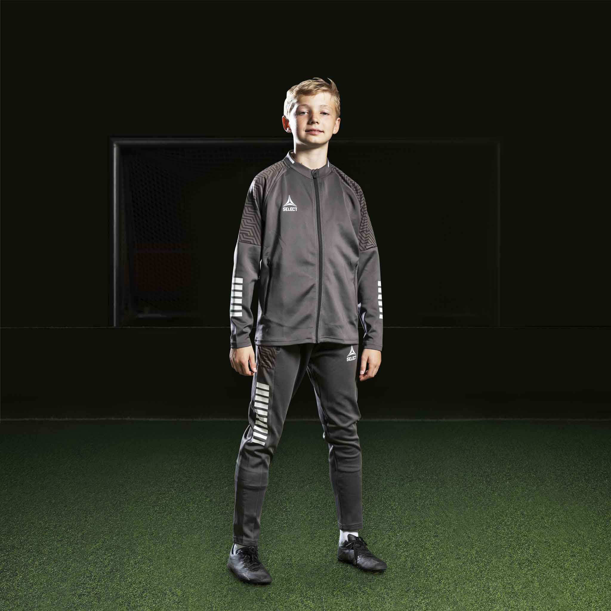 Fotbollsspelande pojke i grå och vit Zip jacket Monaco v24, Match & Training wear.