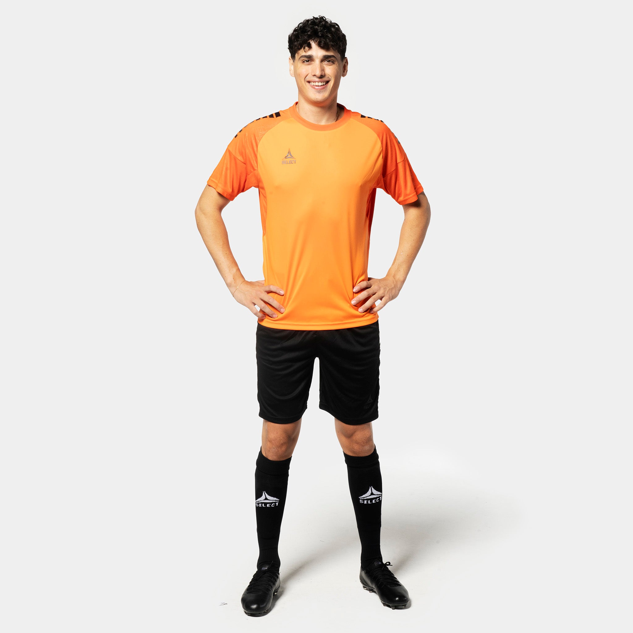 Manlig fotbollsspelare i orange tröja & svarta Player shorts Spain v25, Match- & träningskläder, framifrån