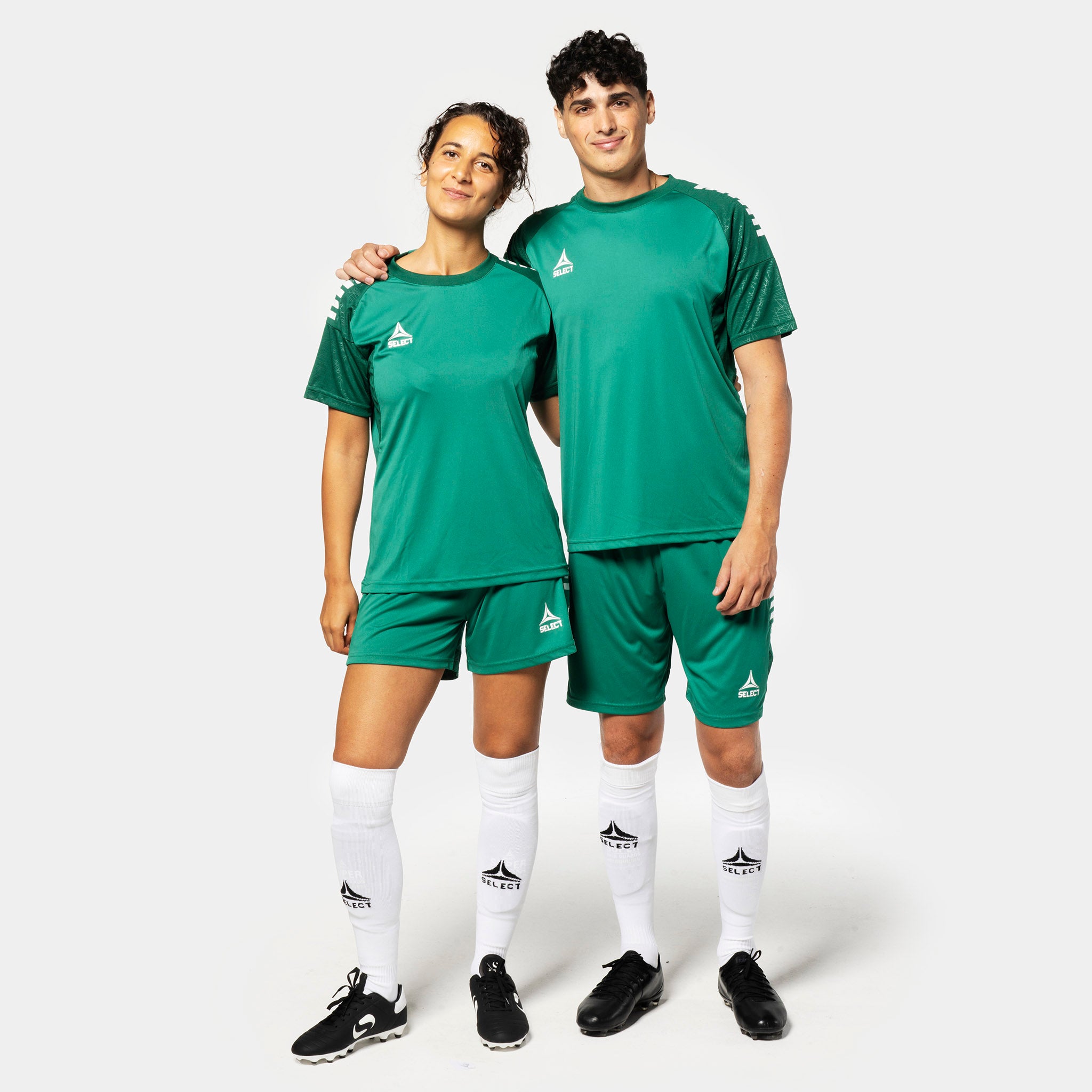 Kvinnlig och manlig fotbollsspelare i gröna Player shorts Spain v25, Match & Training wear, med matchande tröjor och vita strumpor.