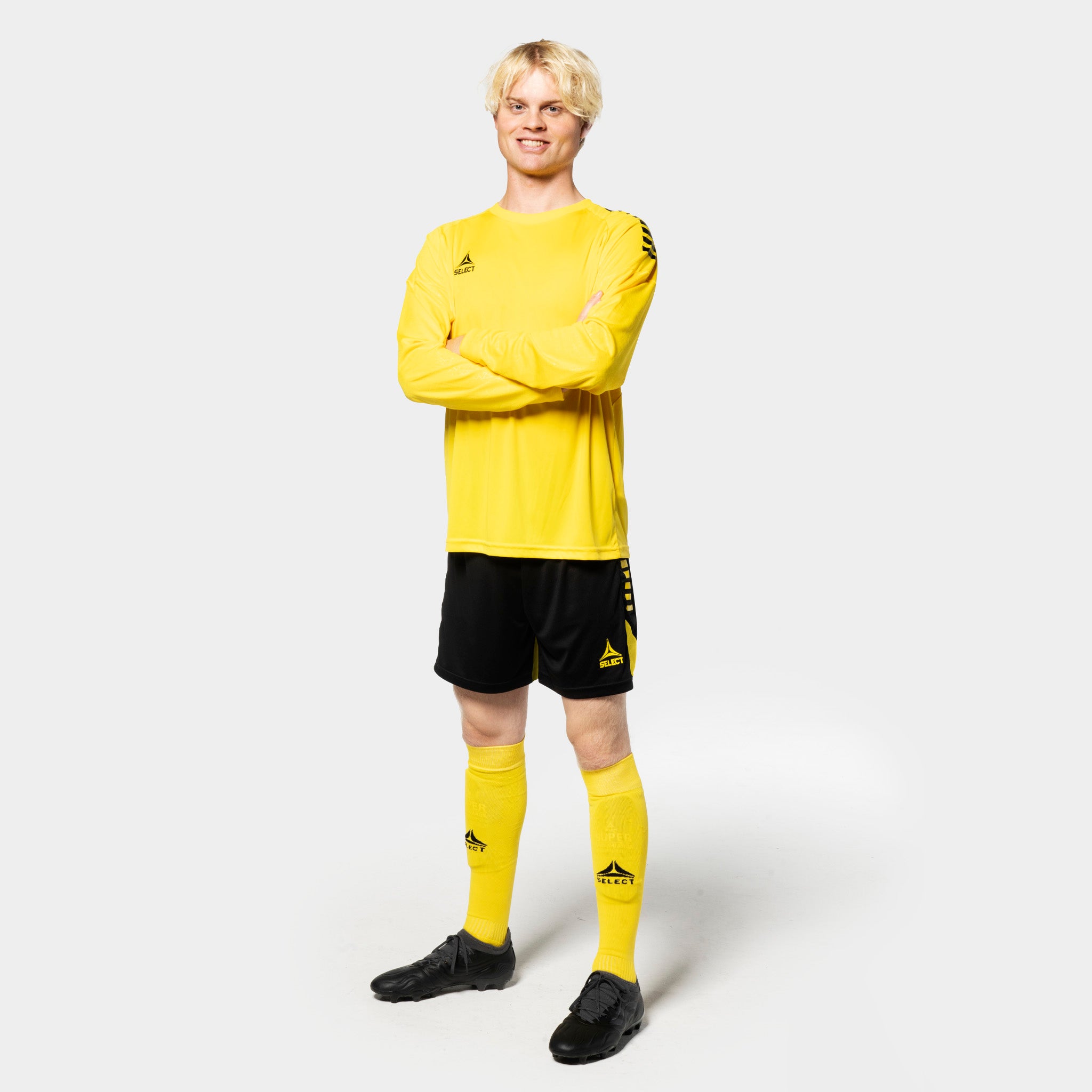 Manlig fotbollsspelare i gul Player shirt L/S Spain v25, svarta shorts, gula strumpor. Match & Training wear, framifrån.
