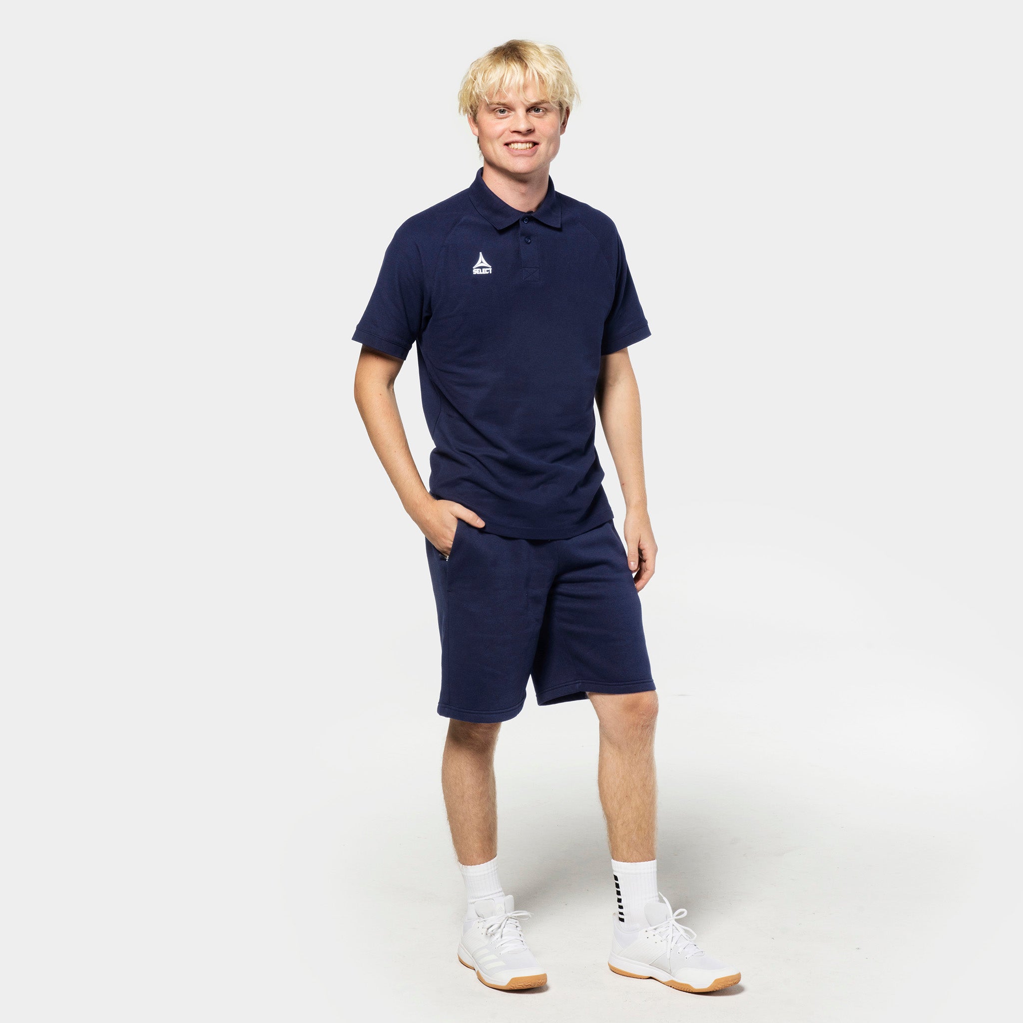 Manlig fotbollsspelare i marinblå Sweat shorts Oxford v25 och matchande piké, Leisure wear, framifrån.
