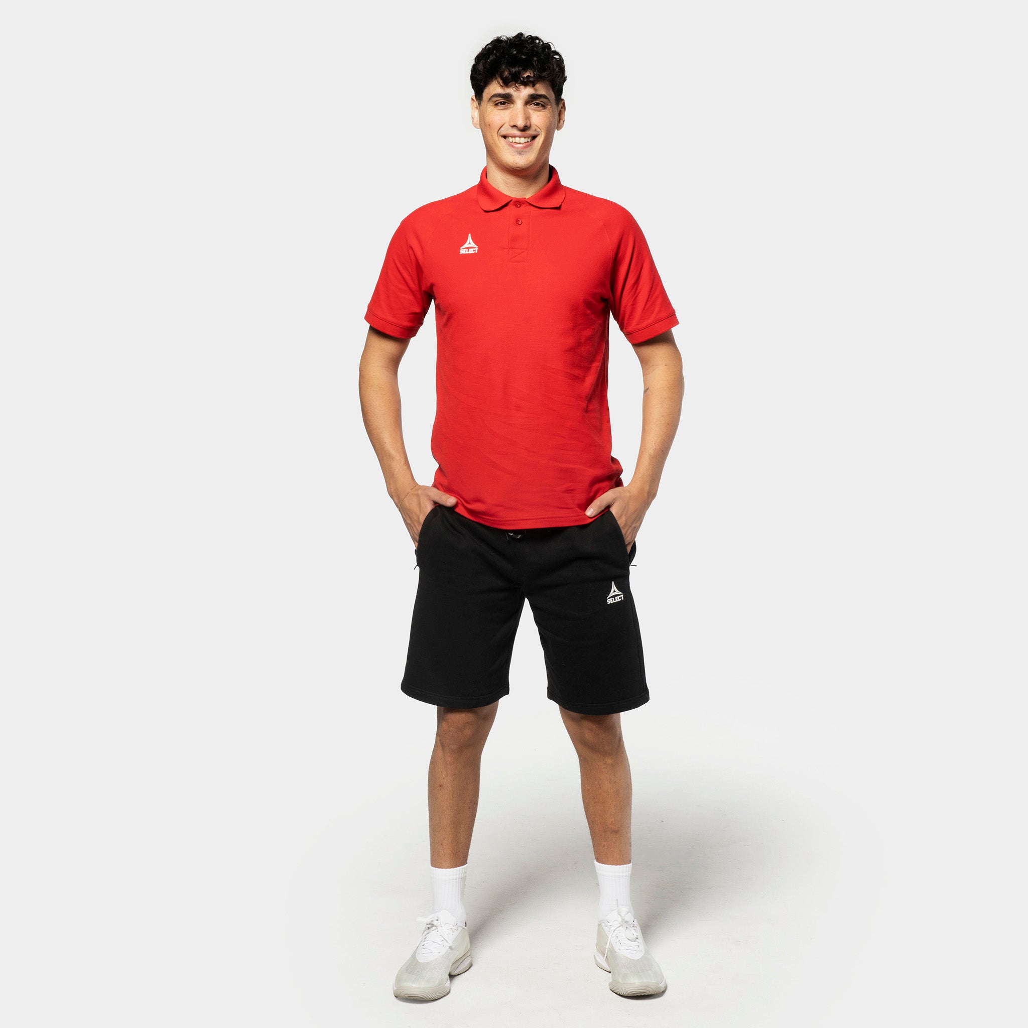 Man i röd piké och svarta Sweat shorts Oxford v25, fritidskläder, fotbollsspelare framifrån.