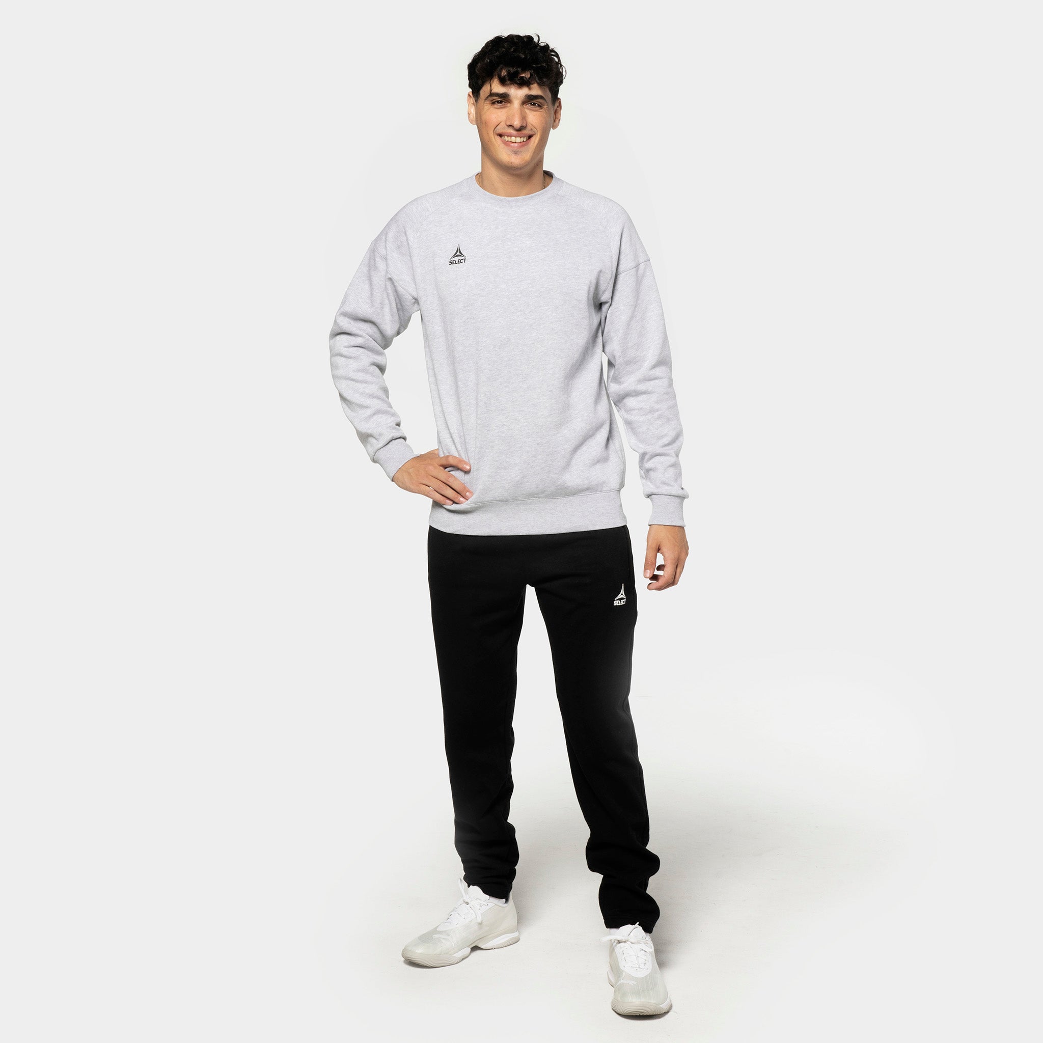 Manlig fotbollsspelare i grå sweatshirt och svarta Sweat pants Oxford v25, fritidskläder, framifrån.