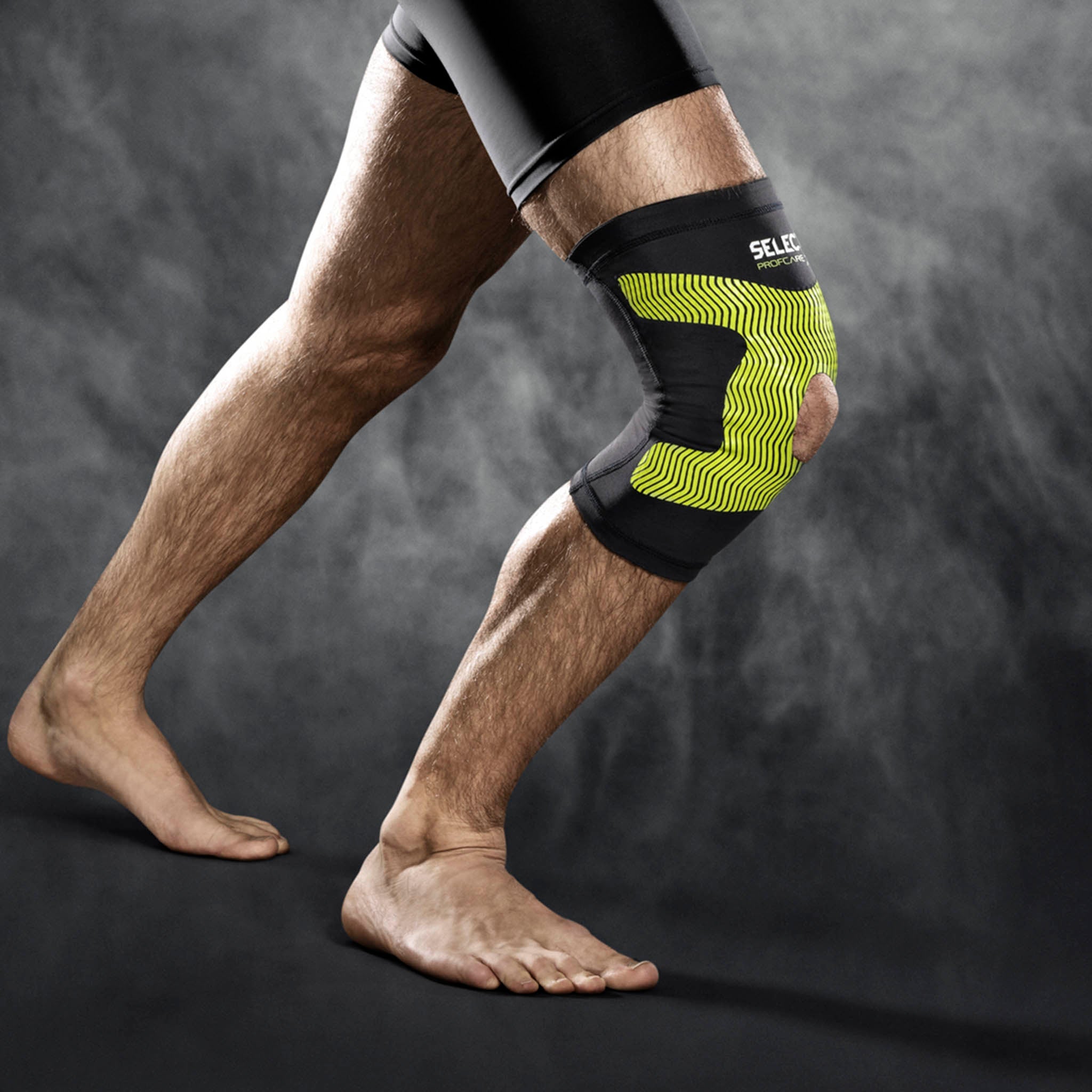 Mand iført sort og gul Compression knee support 6252, sportsstøtte, på knæet