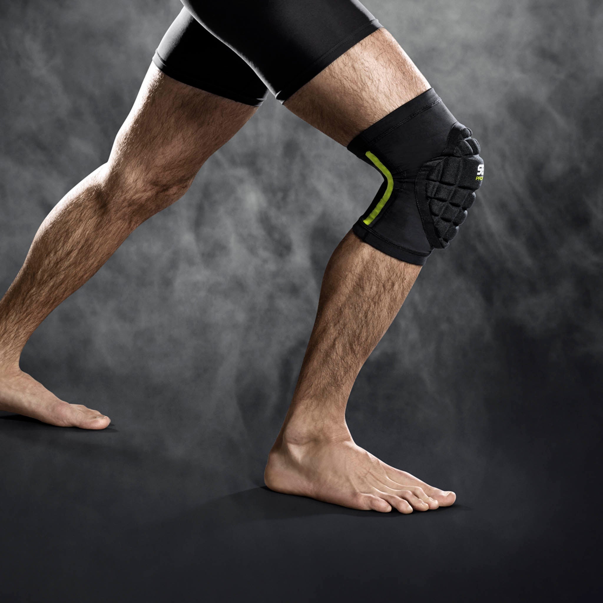 Sort Compression knee handball 6250 sportsstøtte med grøn detalje, båret på knæ, forside