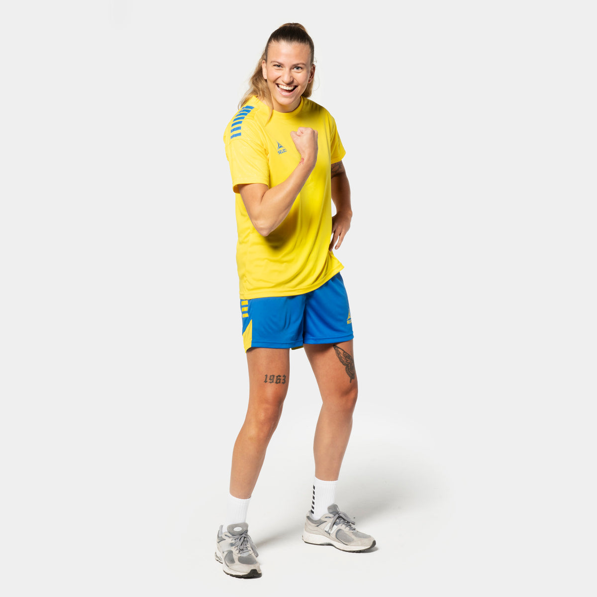 Kvinnlig fotbollsspelare i gul Player shirt S/S Spain woman v25, blå Player shorts Spain woman v25, Match & Training wear, framsida
